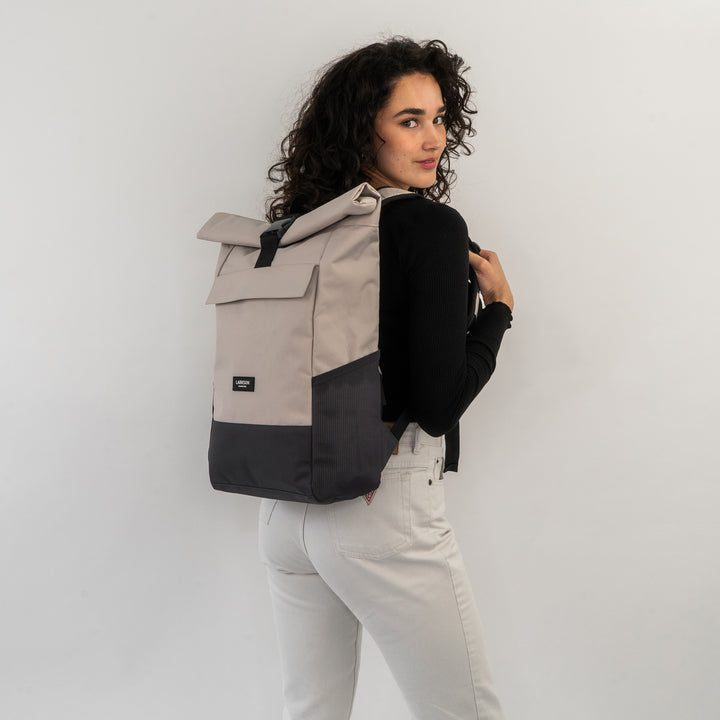 Frau trägt LARKSON Rolltop Rucksack No 4 in Beige und Grau, seitliche Ansicht