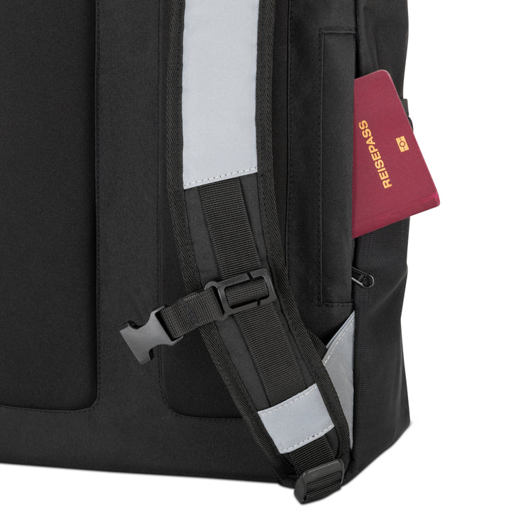 Schwarzer Rolltop Rucksack No 2 mit reflektierendem Schultergurt und rotem Reisepass in seitlicher Tasche