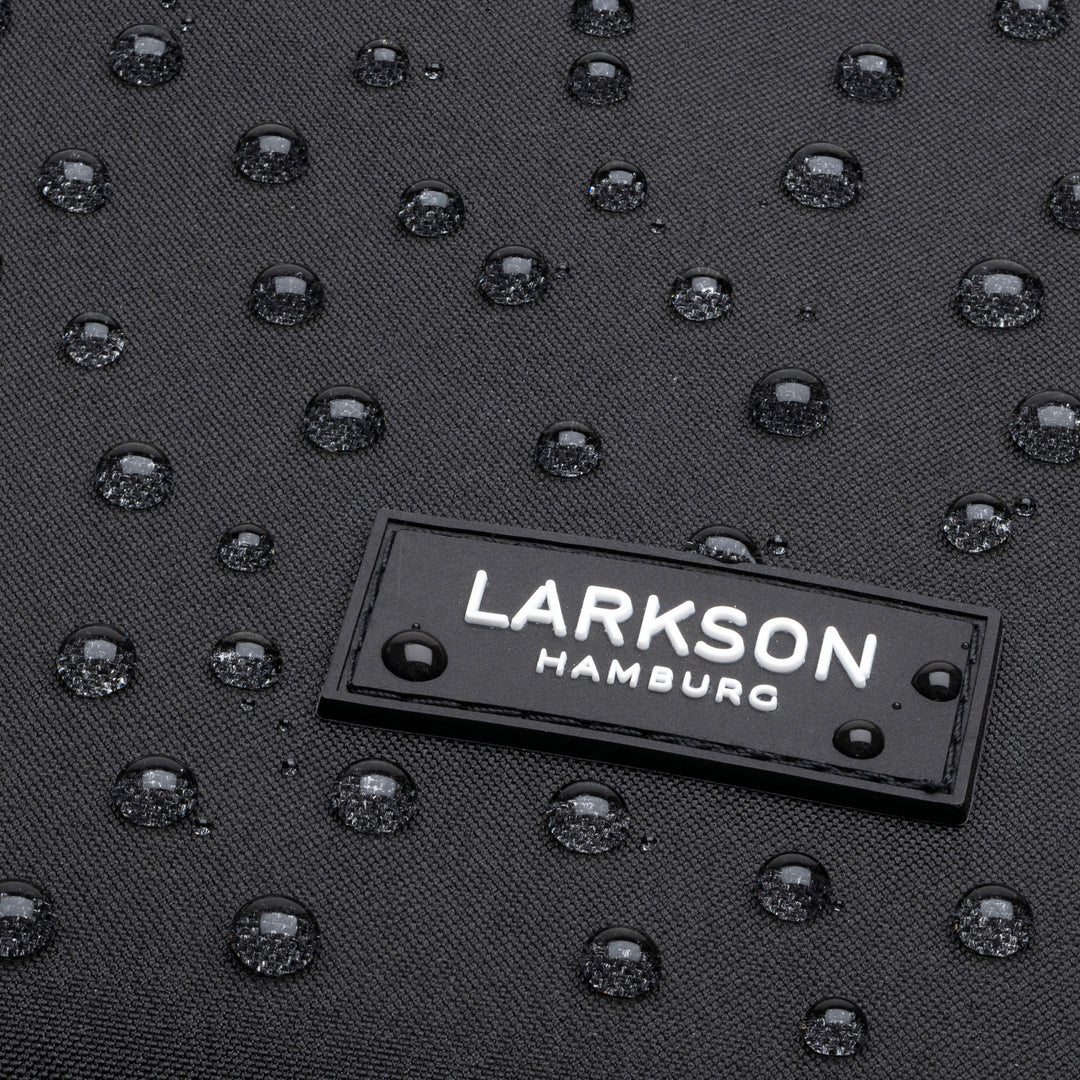 Schwarzes wasserabweisendes Material mit Wassertropfen und LARKSON Hamburg Logo auf dem Rolltop Rucksack No 2