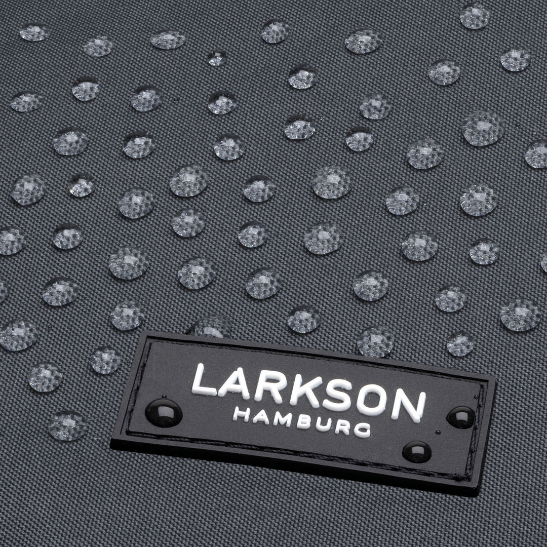 Nahaufnahme eines anthrazitfarbenen LARKSON Rolltop Rucksacks mit wasserabweisendem Material und Wassertropfen