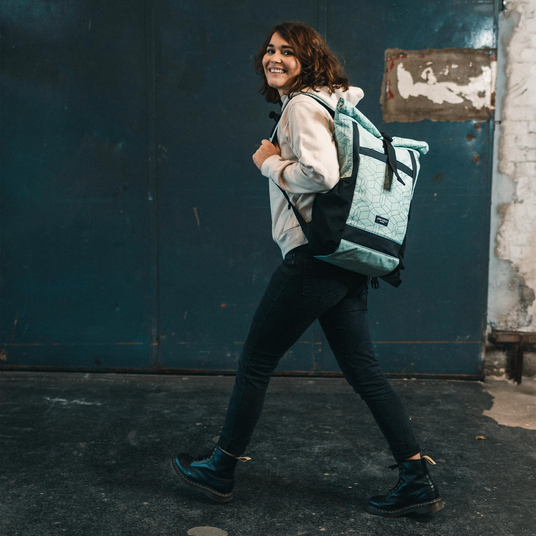 Frau trägt mintgrünen Rolltop Rucksack No 2 mit geometrischem Muster von LARKSON
