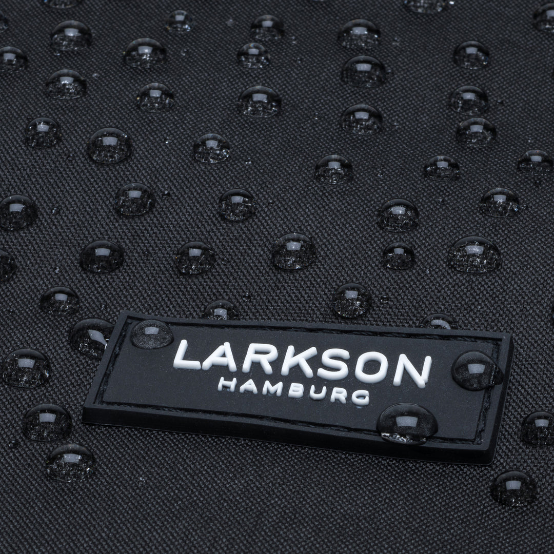 Nahaufnahme des wasserabweisenden Materials mit LARKSON Hamburg Logo auf Rolltop Rucksack No 4