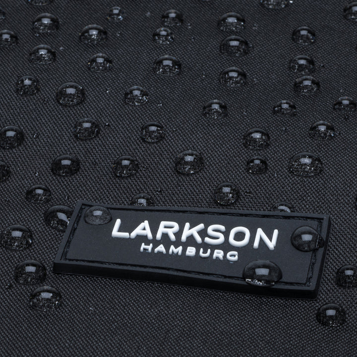 Nahaufnahme des wasserabweisenden Materials mit LARKSON Hamburg Logo auf Rolltop Rucksack No 4