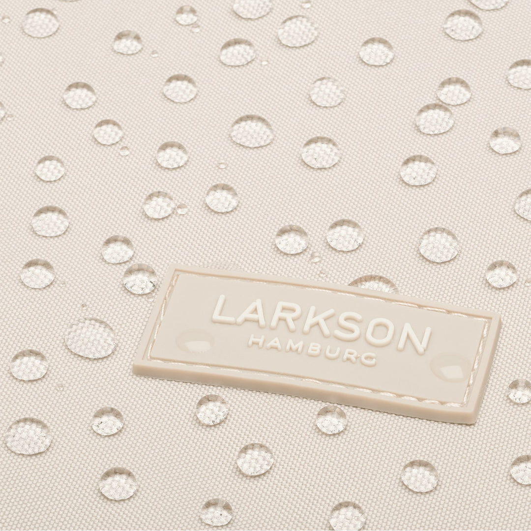 Nahaufnahme des wasserabweisenden Materials des LARKSON Rucksacks Niklas mit aufgenähtem Logo