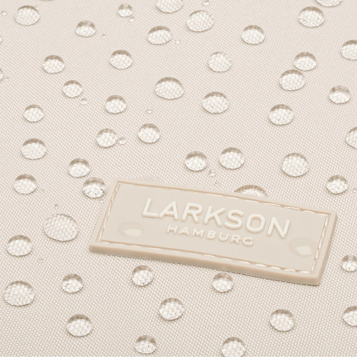 Nahaufnahme des wasserabweisenden Materials des LARKSON Rucksacks Niklas mit aufgenähtem Logo