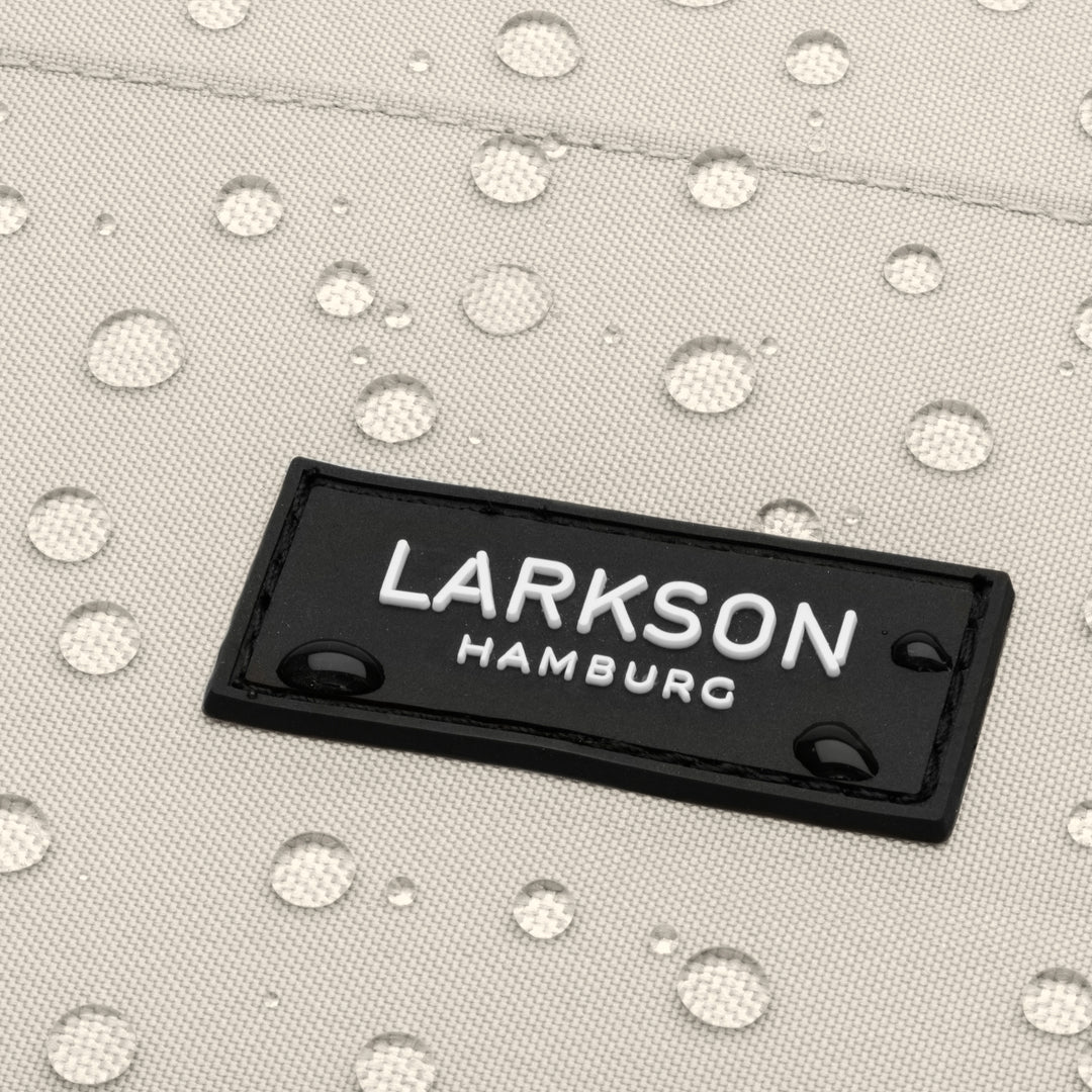 Nahaufnahme des LARKSON Hamburg Logos auf wasserabweisendem Rucksackstoff mit Wassertropfen