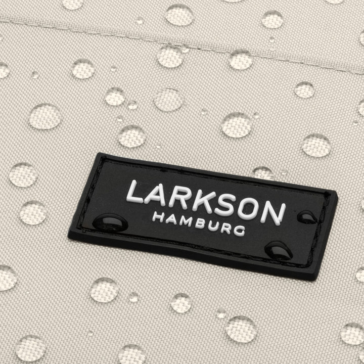 Nahaufnahme des LARKSON Hamburg Logos auf wasserabweisendem Rucksackstoff mit Wassertropfen