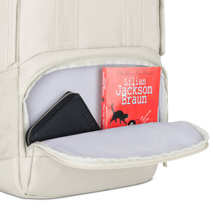 Beige Rucksack No 6 mit geöffneter Fronttasche, darin schwarzes Portemonnaie und rotes Buch