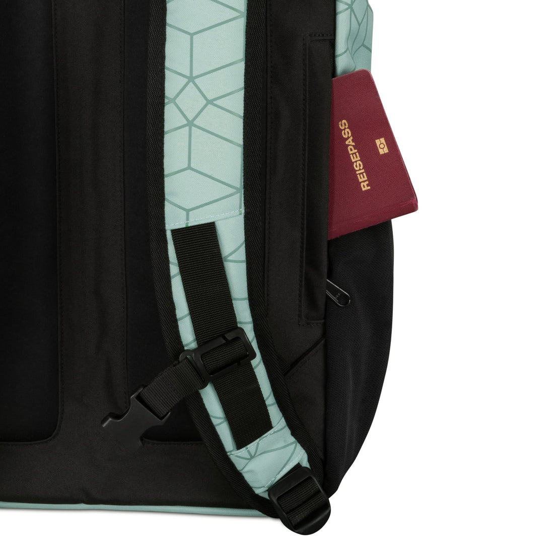 Seitlicher Ausschnitt des Rolltop Rucksack No 2 mit hellblau-schwarz geometrischem Muster und einem roten Reisepass in seitlicher Tasche