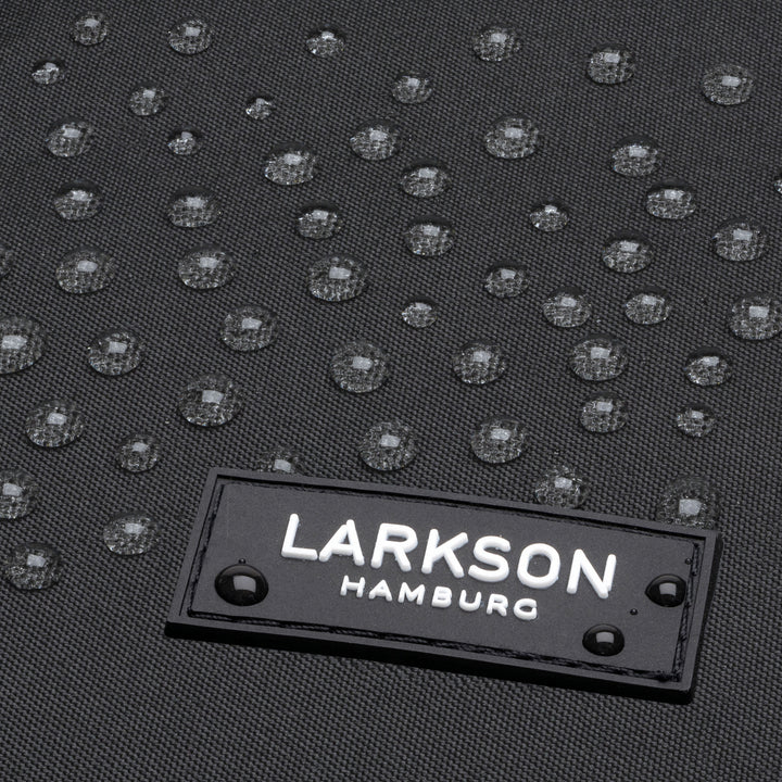 Nahaufnahme von wasserabweisendem schwarzem Gewebe mit LARKSON Hamburg Logo und Wassertröpfchen
