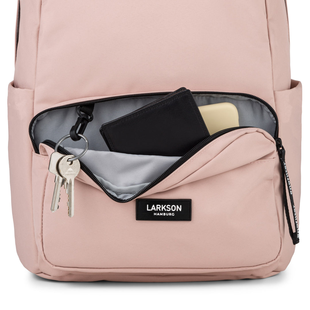 Vorne geöffneter rosa Rucksack No 3 von LARKSON mit Schlüsselanhänger, schwarzem Portemonnaie und hellgelbem Objekt in der Außentasche