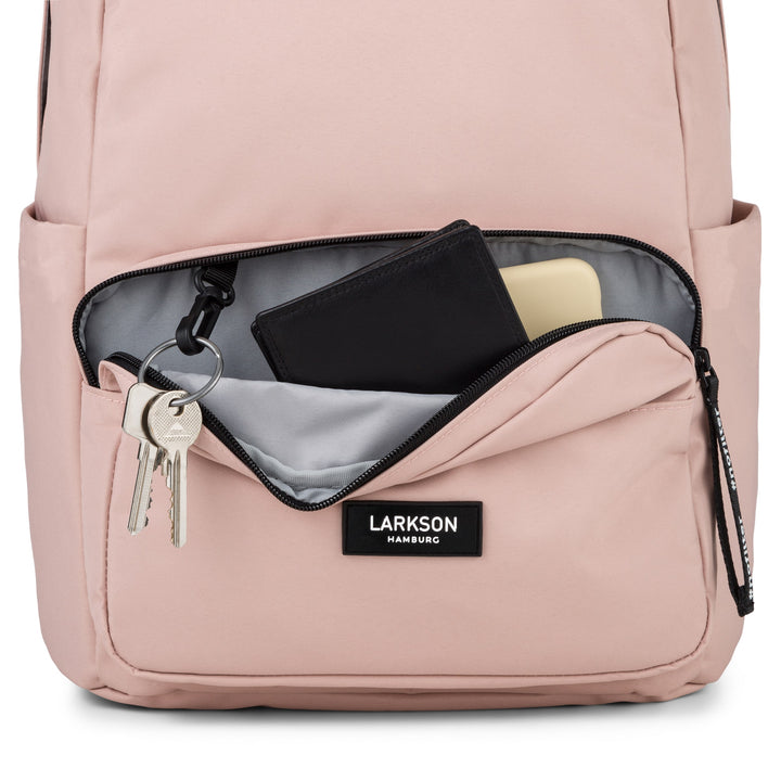 Vorne geöffneter rosa Rucksack No 3 von LARKSON mit Schlüsselanhänger, schwarzem Portemonnaie und hellgelbem Objekt in der Außentasche