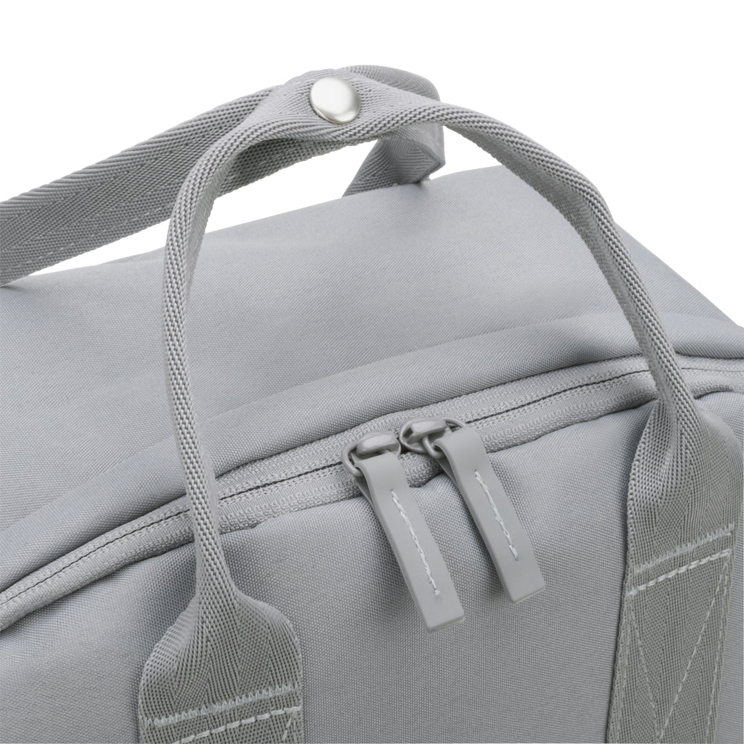 Nahe Aufnahme des oberen Teils des hellgrauen Rucksack No 6 mit Doppelreißverschluss und Henkel.