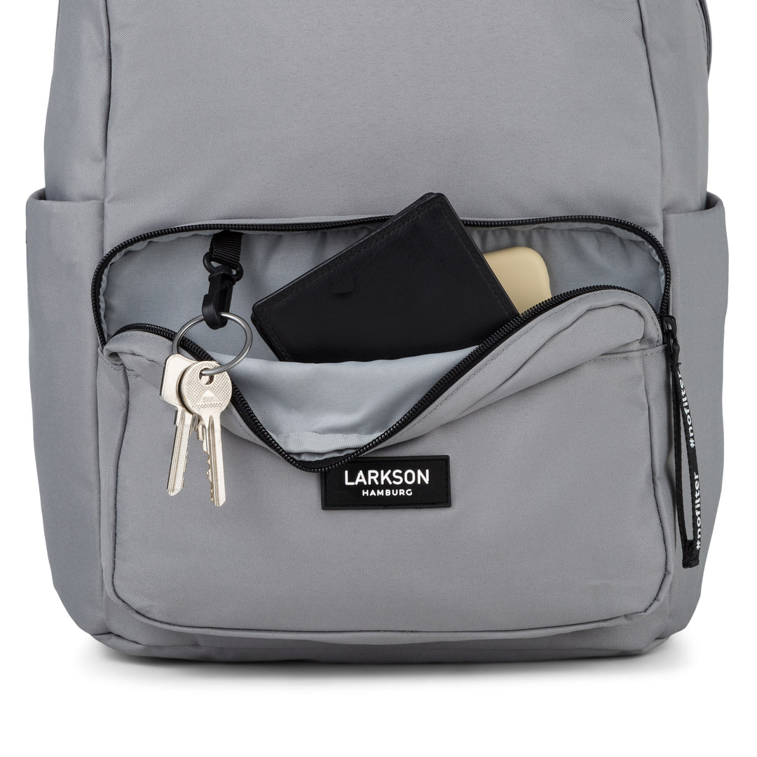 Hellgrauer Larkson Rucksack No 3 mit geöffnetem vorderem Fach, Schlüsselanhänger, Geldbörse und Handy