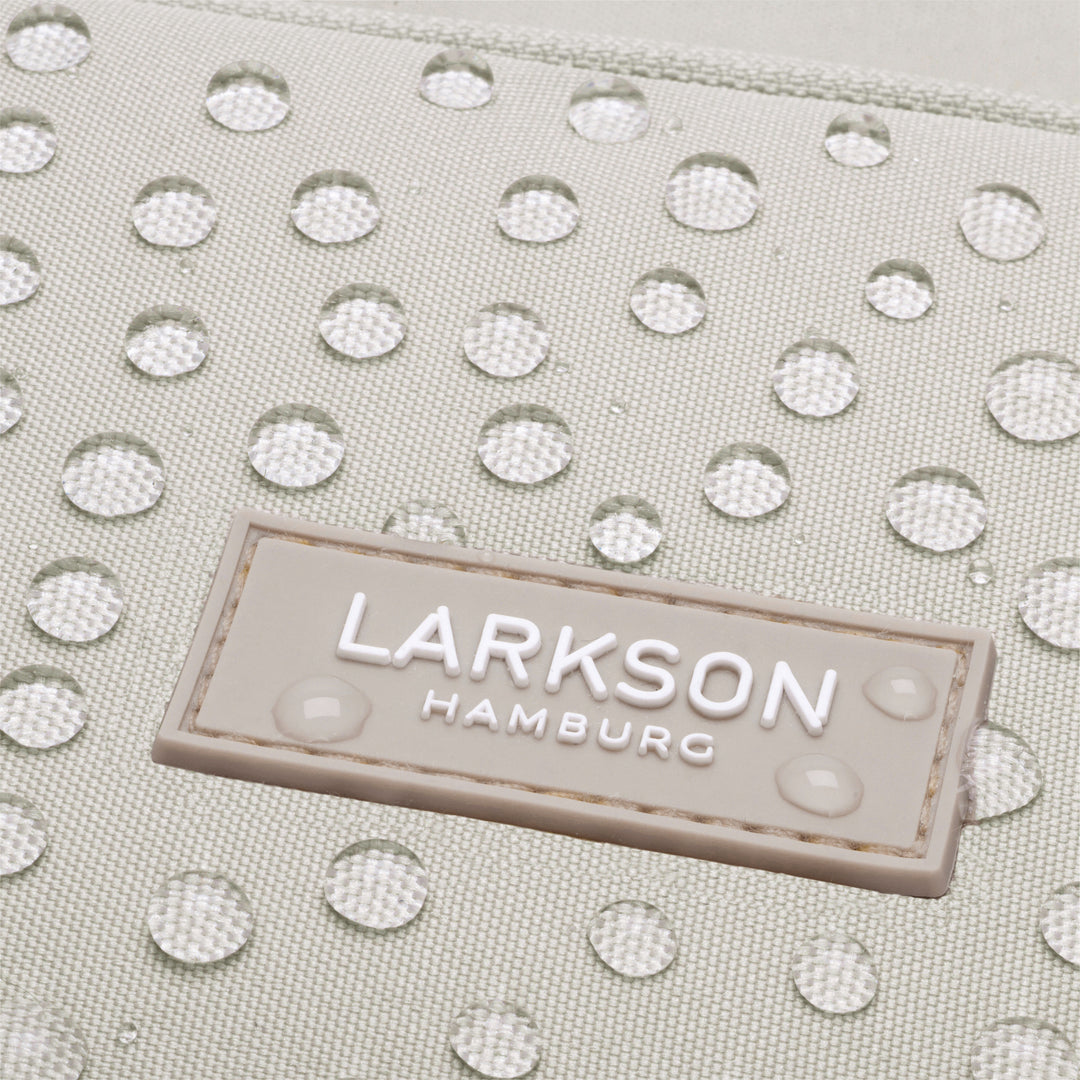 Wasserabweisendes Gewebe mit LARKSON Hamburg Logo auf beigem Rucksack
