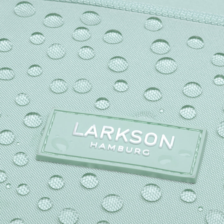 Nahaufnahme des wasserabweisenden, mintgrünen Stoffes des Rucksack No 6 mit LARKSON Hamburg Logo
