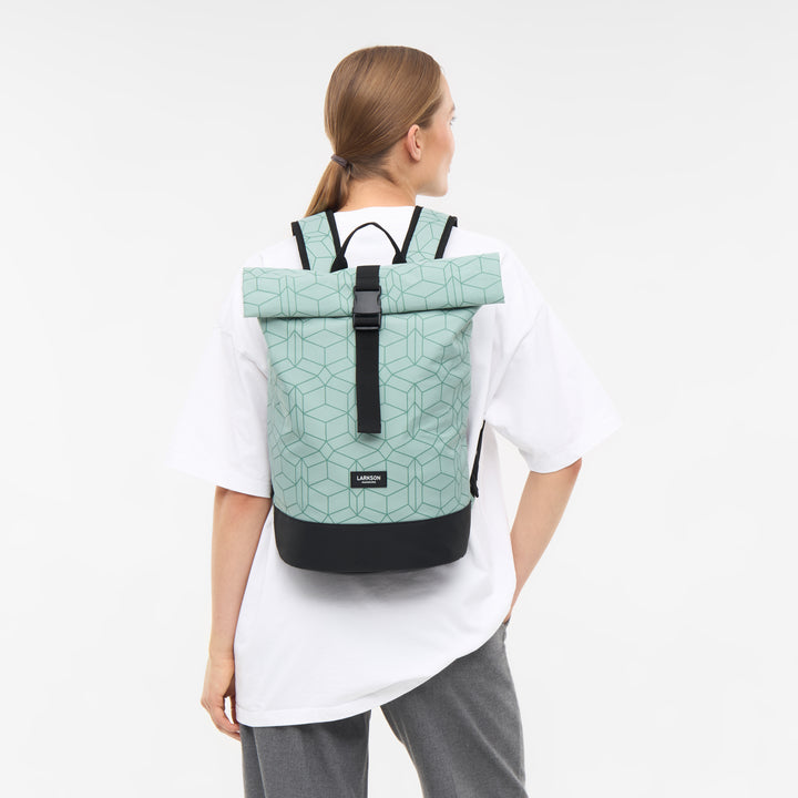 Frau mit Rolltop Rucksack Janne Small von Larkson in Mintgrün mit geometrischem Muster und schwarzem Boden