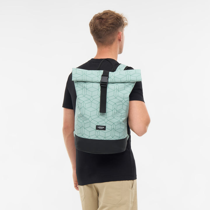Mann von hinten mit LARKSON Rolltop Rucksack Janne Small in hellgrün mit geometrischem Muster