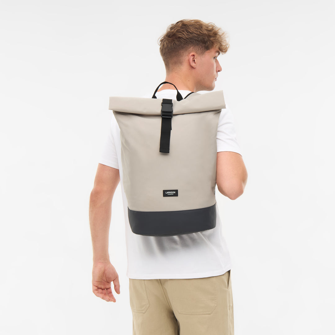 Herren mit beige-schwarzem Rolltop Rucksack Janne Small von LARKSON, von hinten gesehen