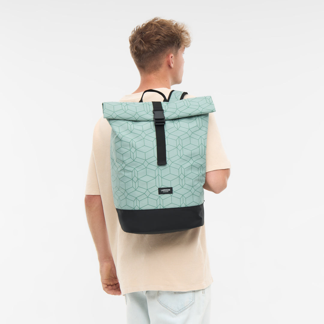 Mann von hinten trägt mintgrünen Rolltop Rucksack Janne mit geometrischem Muster und schwarzem Boden von Larkson