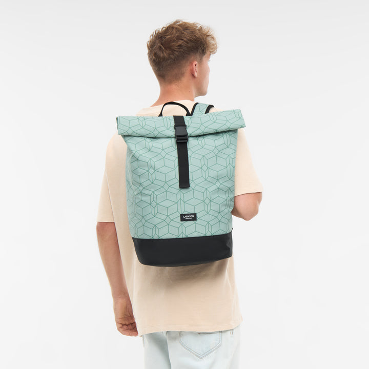 Mann von hinten trägt mintgrünen Rolltop Rucksack Janne mit geometrischem Muster und schwarzem Boden von Larkson