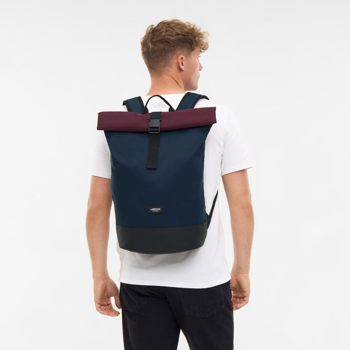 Herren mit Rolltop Rucksack Janne in dunkelblau mit bordeauxrotem Rollverschluss und schwarzem Boden