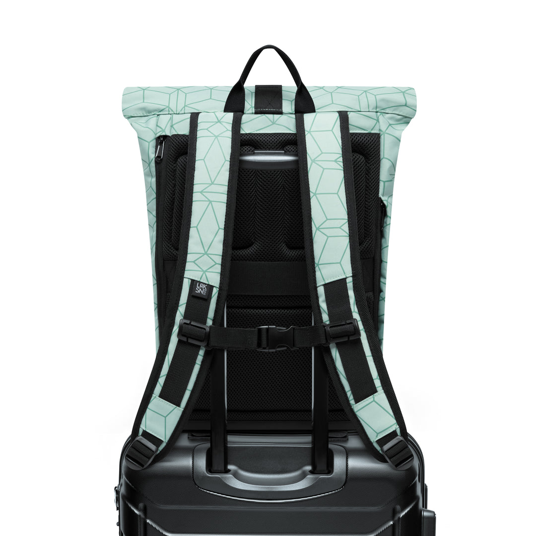 Rolltop Rucksack Janne Small in Mint mit geometrischem Muster von hinten, darauf befestigt an schwarzem Rollkoffer