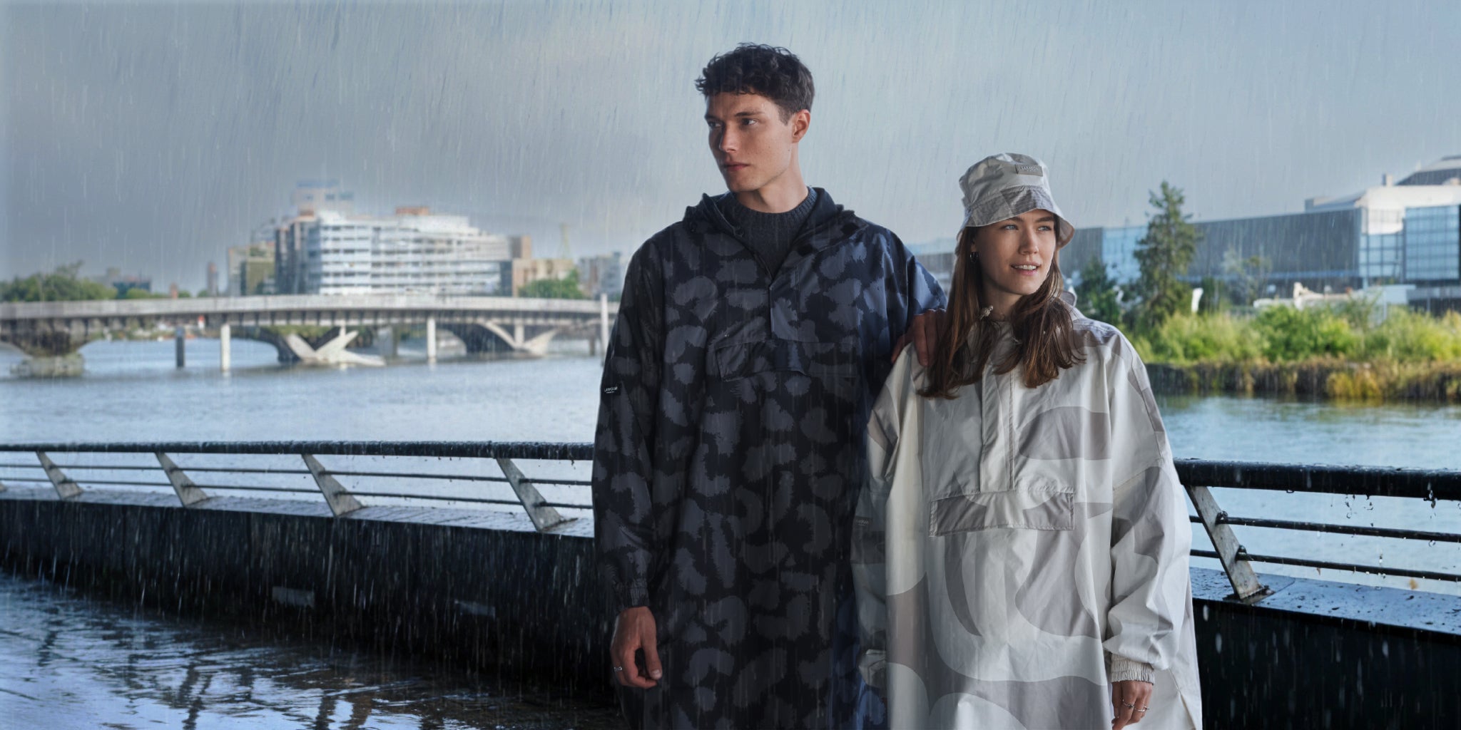 Frau und Mann stehen im Regen mit Regenponcho von Larkson.