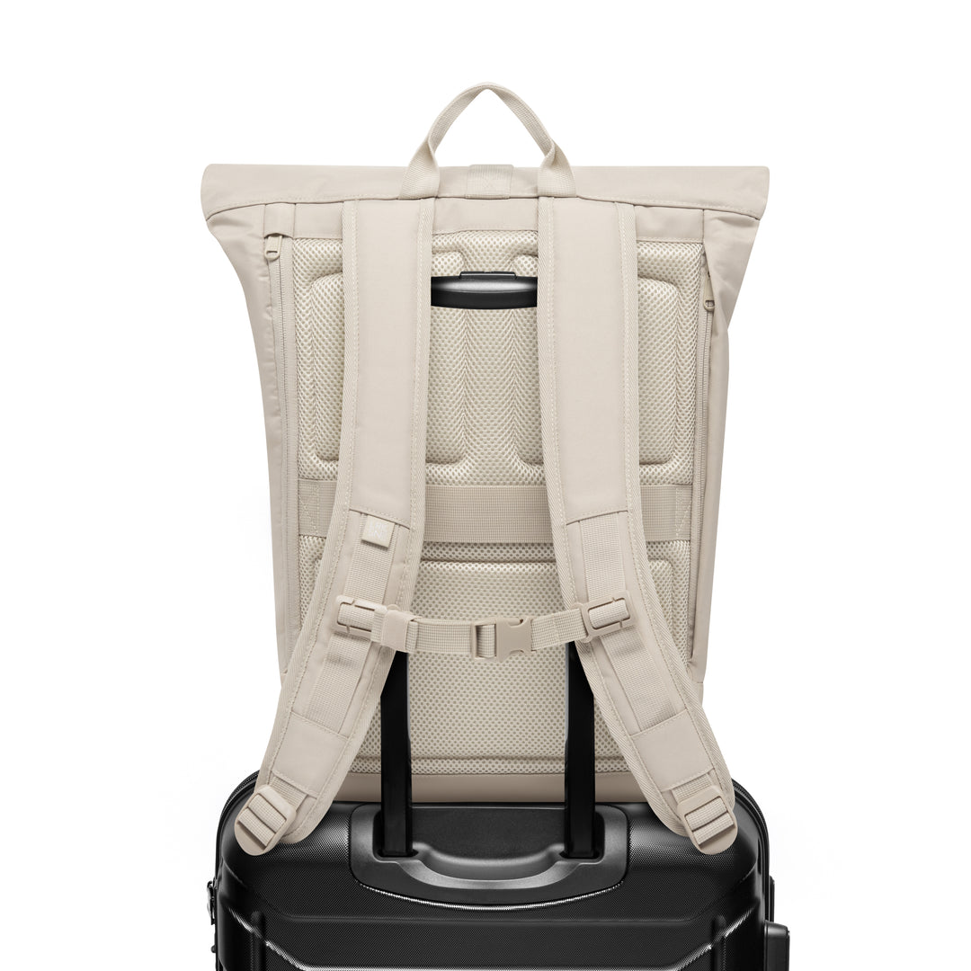 Rückansicht des sandfarbenen Rolltop Rucksack Janne auf einem schwarzen Trolleygriff