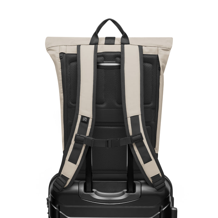 Rückansicht des Rolltop Rucksacks Janne in sandgrauer Farbe mit gepolsterten Schultergurten und befestigt an einem Trolley-Griff
