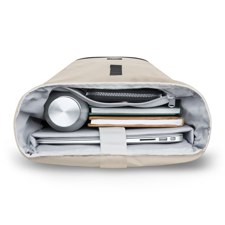 Innenansicht des offenen beigen Rolltop Rucksack Janne Small mit Laptop, Büchern, Federmäppchen und Trinkflasche