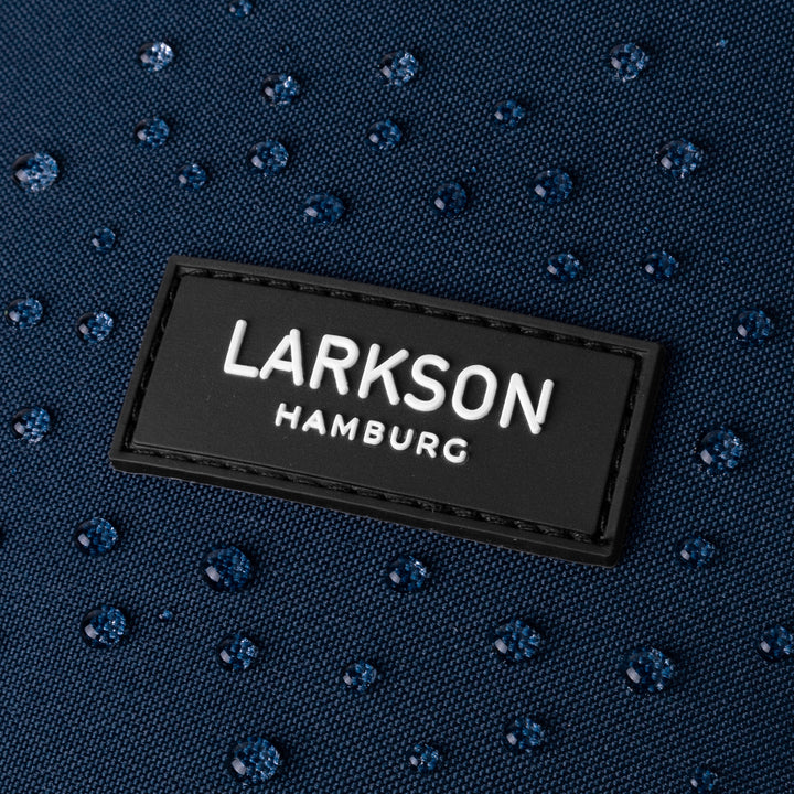 Nahaufnahme des LARKSON Hamburg Logos auf wasserabweisendem Stoff mit Wassertropfen