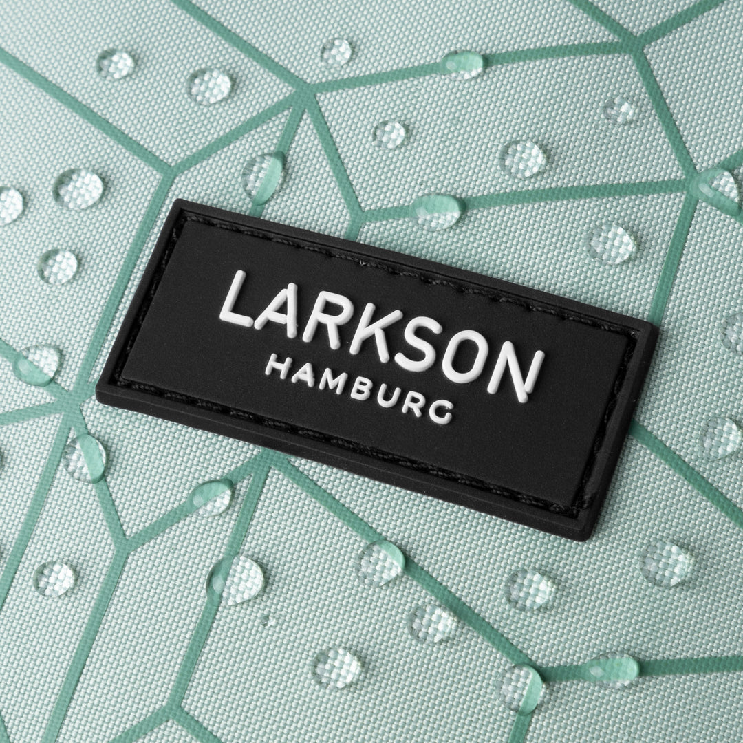 Nahaufnahme des schwarzen LARKSON Hamburg Logos auf mintgrünem, wasserabweisendem Stoff mit geometrischem Muster