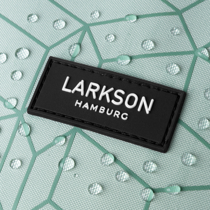 Nahaufnahme des schwarzen LARKSON Hamburg Logos auf mintgrünem, wasserabweisendem Stoff mit geometrischem Muster