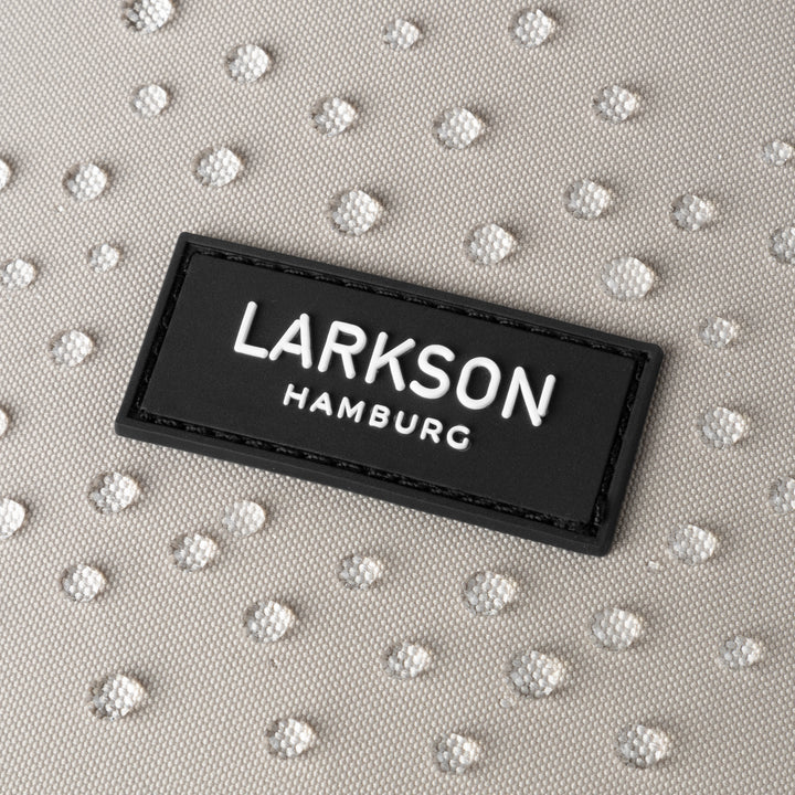 Nahaufnahme des LARKSON Hamburg Logos auf sandgrauem wasserabweisendem Rolltop Rucksack Janne