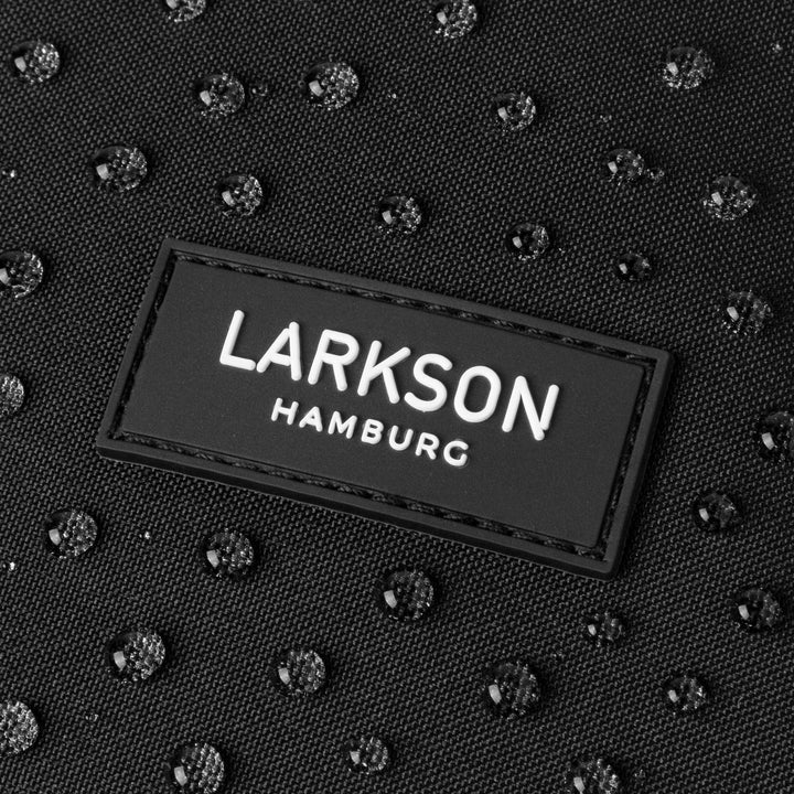 Wasserabweisendes schwarzes Material des Rolltop Rucksacks Janne Small mit LARKSON Hamburg Logo